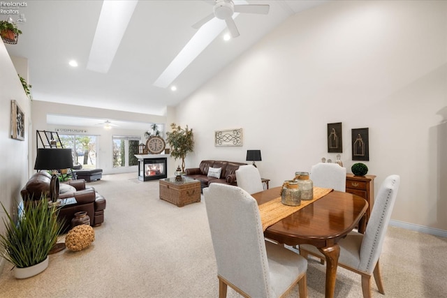 dining space with a skylight, high vaulted ceiling, and ceiling fan