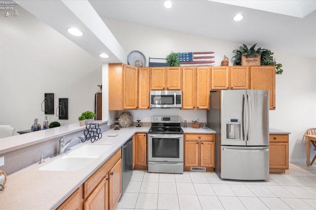 kitchen featuring light tile patterned flooring, sink, vaulted ceiling, kitchen peninsula, and stainless steel appliances