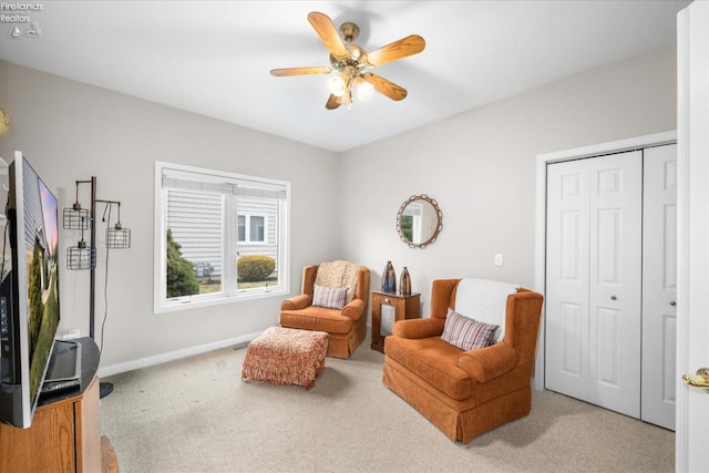 sitting room featuring light colored carpet and ceiling fan