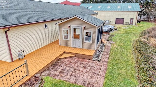 exterior space featuring a wooden deck and a lawn