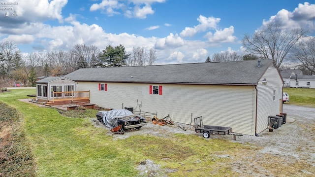 rear view of property with a yard and a sunroom