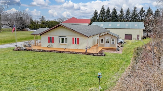 back of property with a wooden deck and a lawn