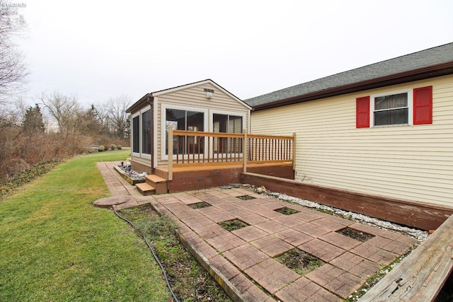 back of house with a lawn, a sunroom, and a patio