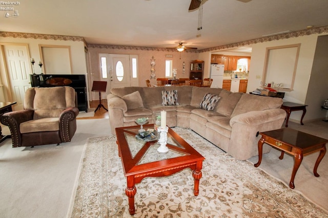 living room with ceiling fan and light colored carpet