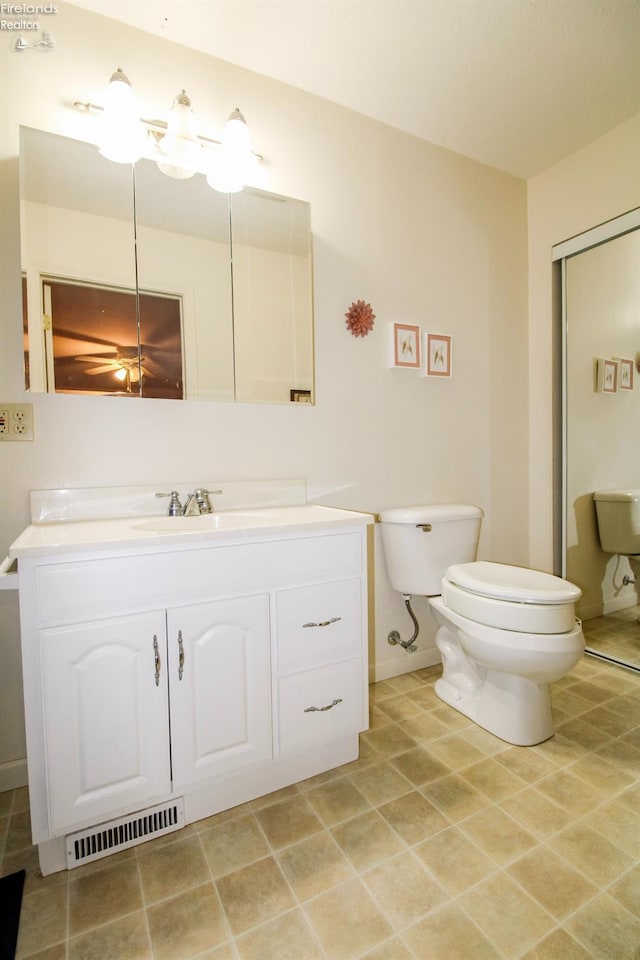 bathroom featuring vanity, toilet, and tile patterned flooring