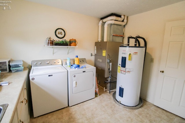 washroom featuring cabinets, washing machine and dryer, and water heater