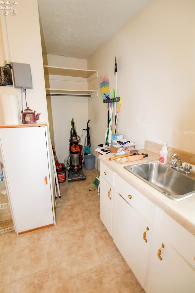 kitchen featuring sink and white cabinets