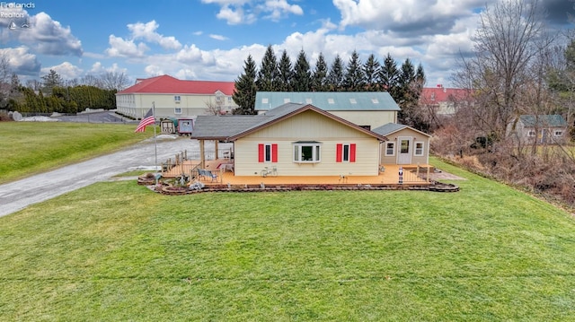 view of front of property featuring a wooden deck and a front lawn