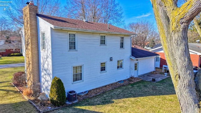 rear view of house with a yard and central AC unit