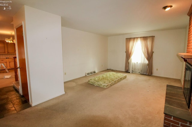 unfurnished living room with carpet and a notable chandelier