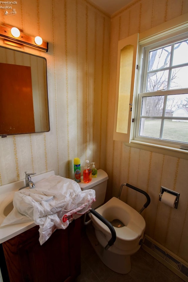 bathroom with vanity, baseboard heating, and toilet