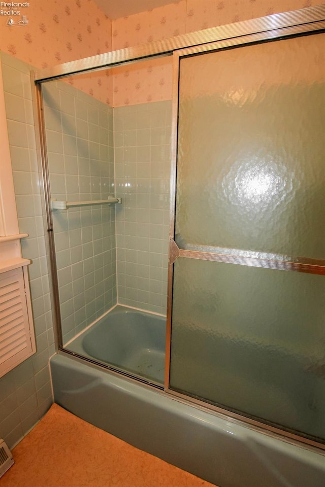 bathroom featuring combined bath / shower with glass door