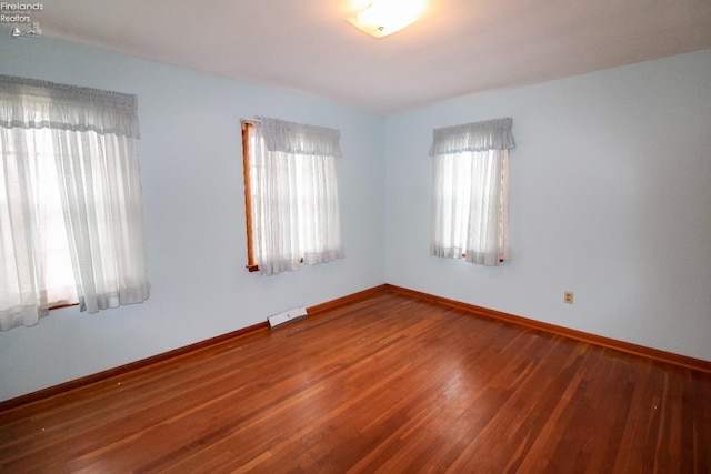 spare room with wood-type flooring