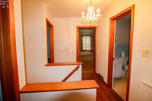 hallway featuring dark wood-type flooring and a chandelier