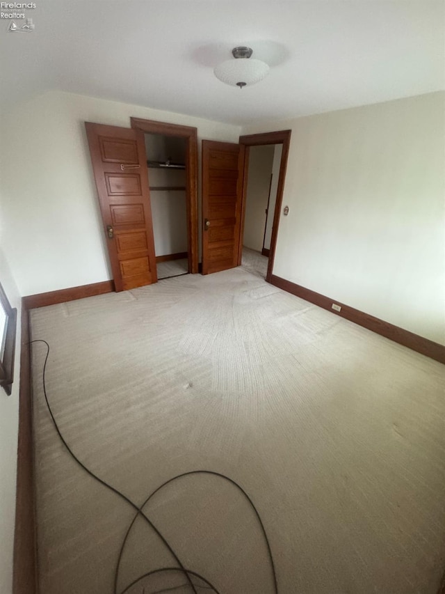 unfurnished bedroom featuring carpet flooring and a closet