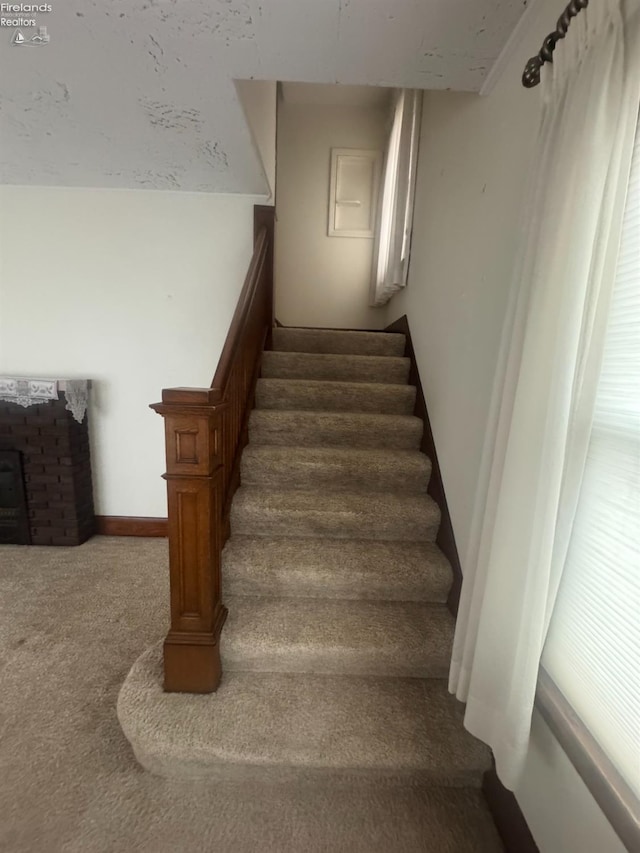 stairway featuring vaulted ceiling and carpet floors