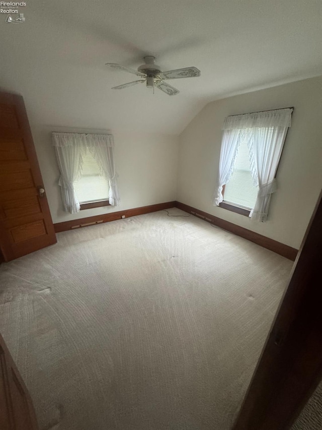 additional living space with vaulted ceiling, carpet, and ceiling fan