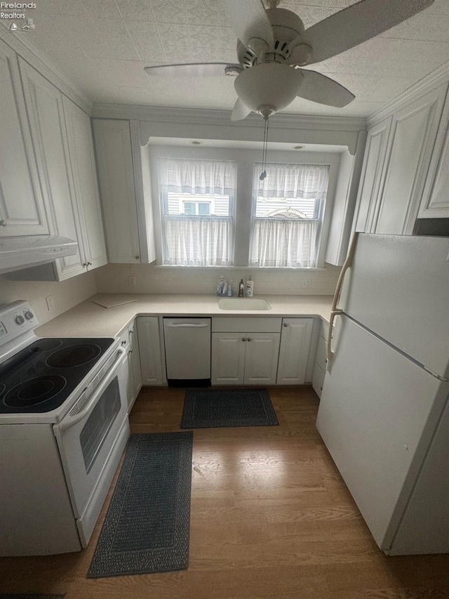 kitchen with sink, white appliances, extractor fan, white cabinets, and light wood-type flooring