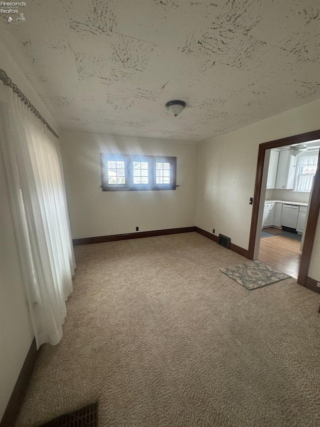 carpeted spare room featuring a textured ceiling