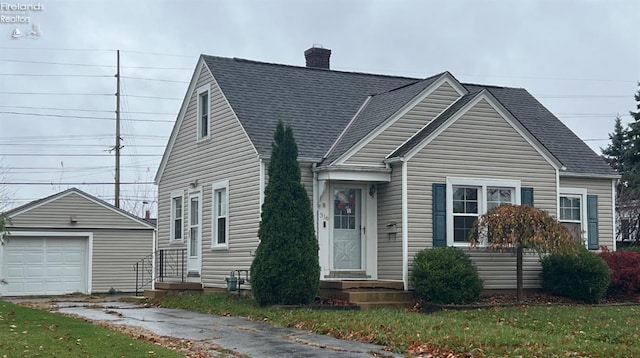 view of front of home with a garage, an outdoor structure, and a front lawn