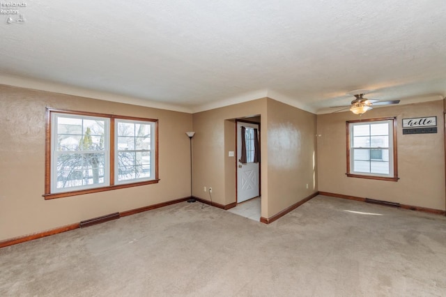 carpeted empty room featuring ceiling fan and a textured ceiling