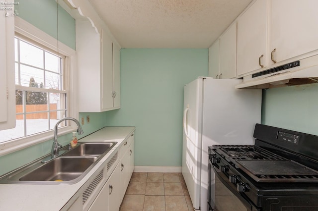 kitchen featuring white cabinetry, gas stove, sink, light tile patterned floors, and a textured ceiling