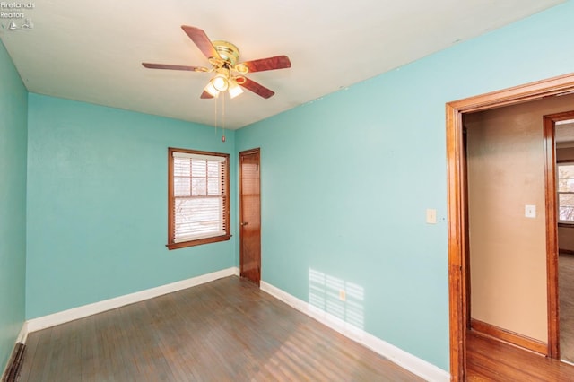 empty room featuring ceiling fan and dark hardwood / wood-style flooring