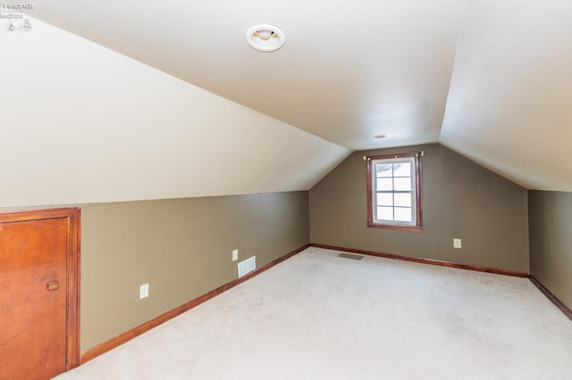 additional living space featuring light carpet and lofted ceiling