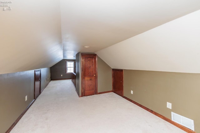 additional living space with vaulted ceiling and light colored carpet