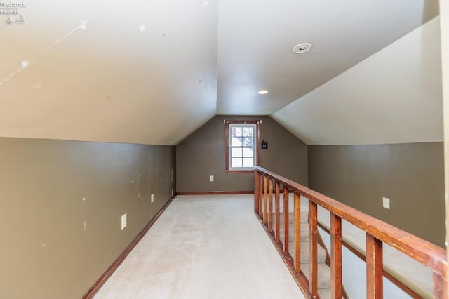 bonus room with vaulted ceiling and light carpet