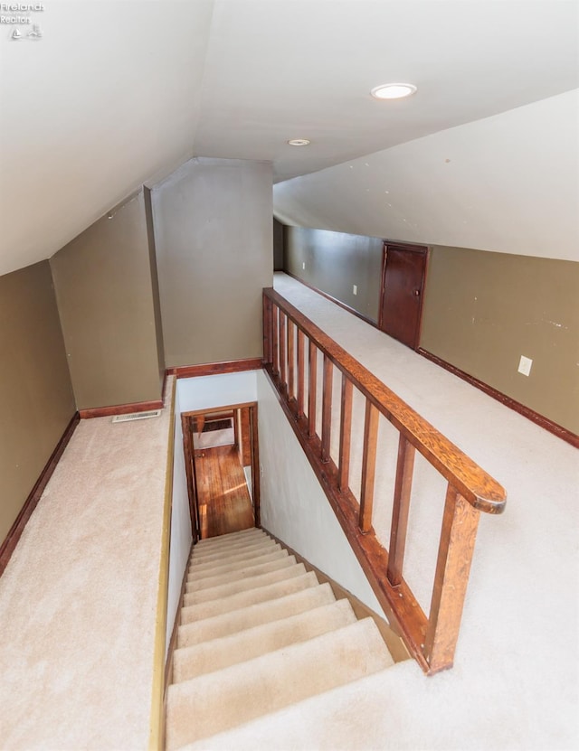 stairway with carpet floors and lofted ceiling