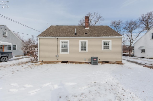 snow covered house with central AC