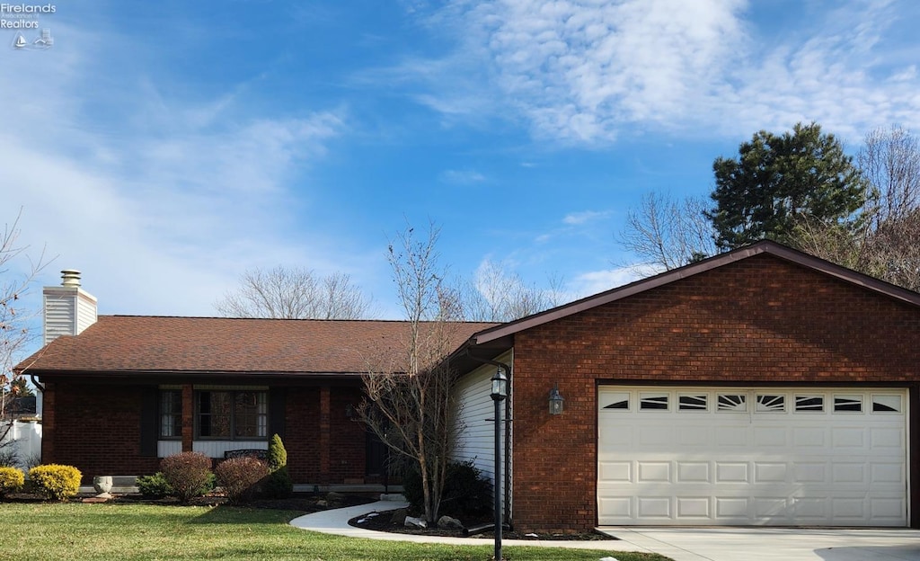 ranch-style home with a garage and a front lawn