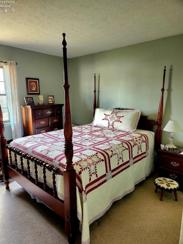 bedroom featuring carpet flooring and a textured ceiling