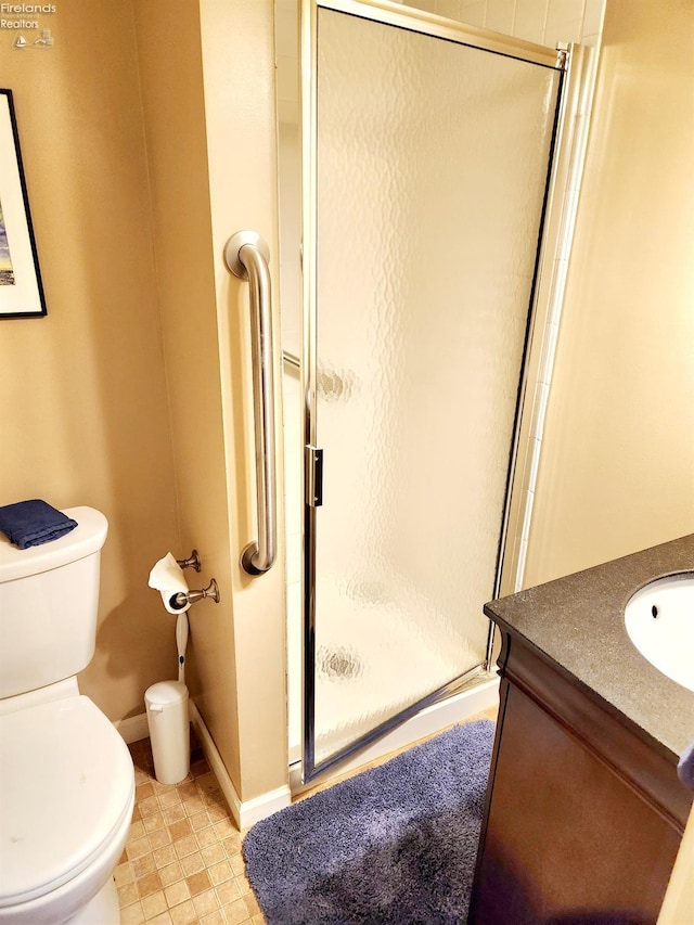 bathroom featuring an enclosed shower, vanity, and toilet