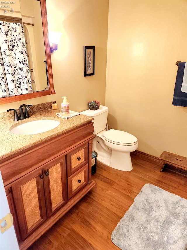 bathroom featuring hardwood / wood-style flooring, vanity, and toilet