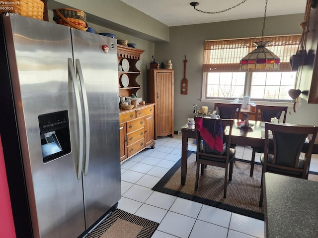 kitchen featuring light tile patterned floors, stainless steel fridge, and decorative light fixtures