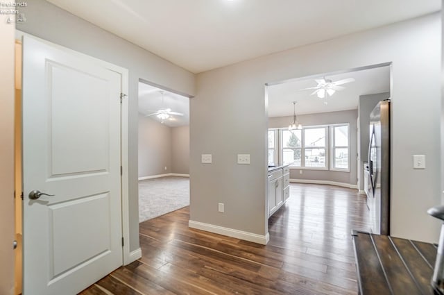 hallway featuring dark hardwood / wood-style floors and an inviting chandelier