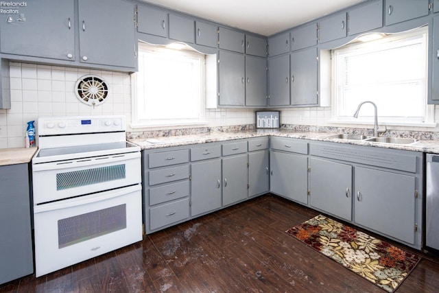 kitchen featuring gray cabinets, light countertops, a sink, and white electric range oven