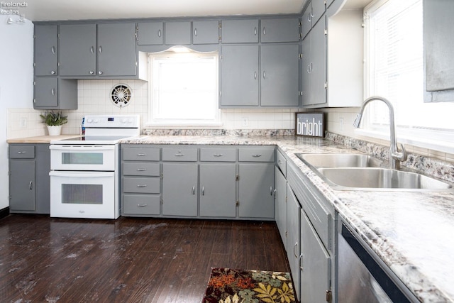 kitchen with range with two ovens, gray cabinetry, a sink, light countertops, and dark wood-style floors