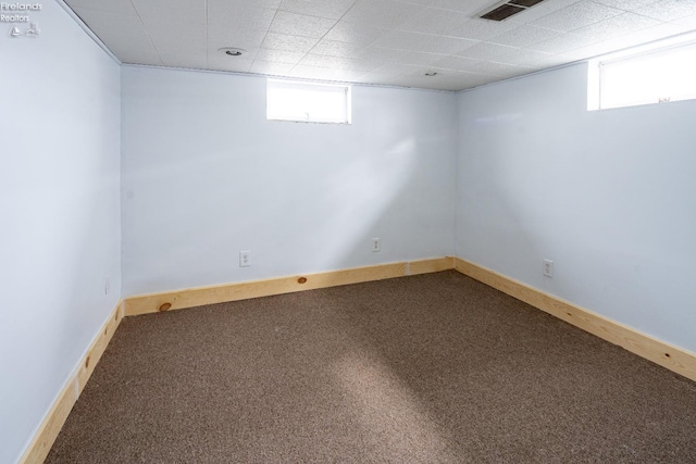 below grade area featuring visible vents, carpet, and a wealth of natural light