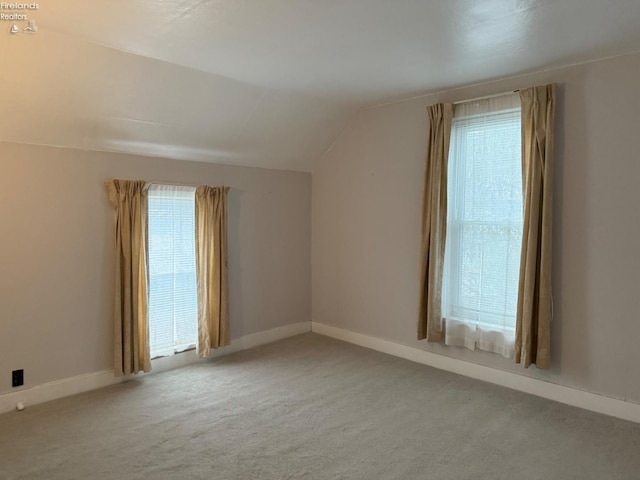 bonus room with vaulted ceiling, a healthy amount of sunlight, and light carpet