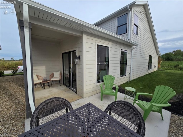 rear view of house featuring a patio area and a lawn