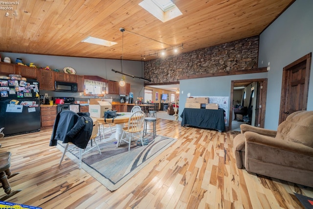 living room with high vaulted ceiling, a skylight, track lighting, wooden ceiling, and light hardwood / wood-style flooring