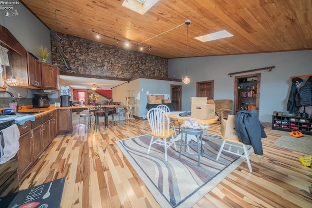 living room with light wood-type flooring, sink, ceiling fan, and a skylight