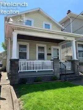 view of front of house featuring covered porch and a front yard