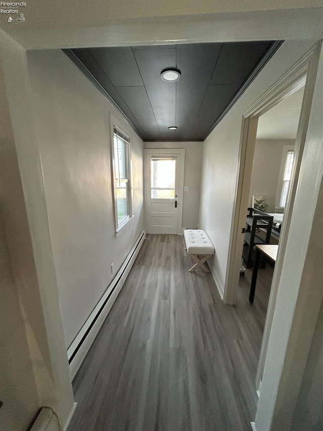 corridor featuring wood-type flooring and baseboard heating