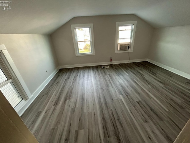 additional living space featuring hardwood / wood-style flooring, vaulted ceiling, and cooling unit