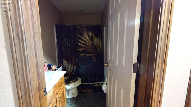 bathroom featuring tile patterned floors, vanity, toilet, and curtained shower