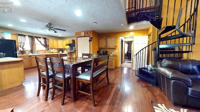 dining room featuring hardwood / wood-style flooring, ceiling fan, and a textured ceiling